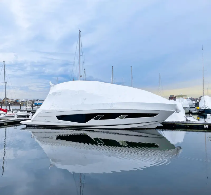 Covered boat wintering in the water at the marina